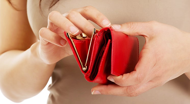 A hand opening a red purse